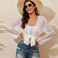 Woman wearing a Geometric Open Front Long Sleeve Cover Up with a hat and sunglasses, styled with distressed denim shorts. Perfect for a chic summer look.