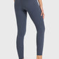 Woman wearing Millennia High Waist Ankle-Length Yoga Leggings in navy, showcasing the stylish high waist and ankle fit.