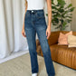 Woman wearing RFM Full Size High Rise Straight Tummy Control Jeans in living room setting.