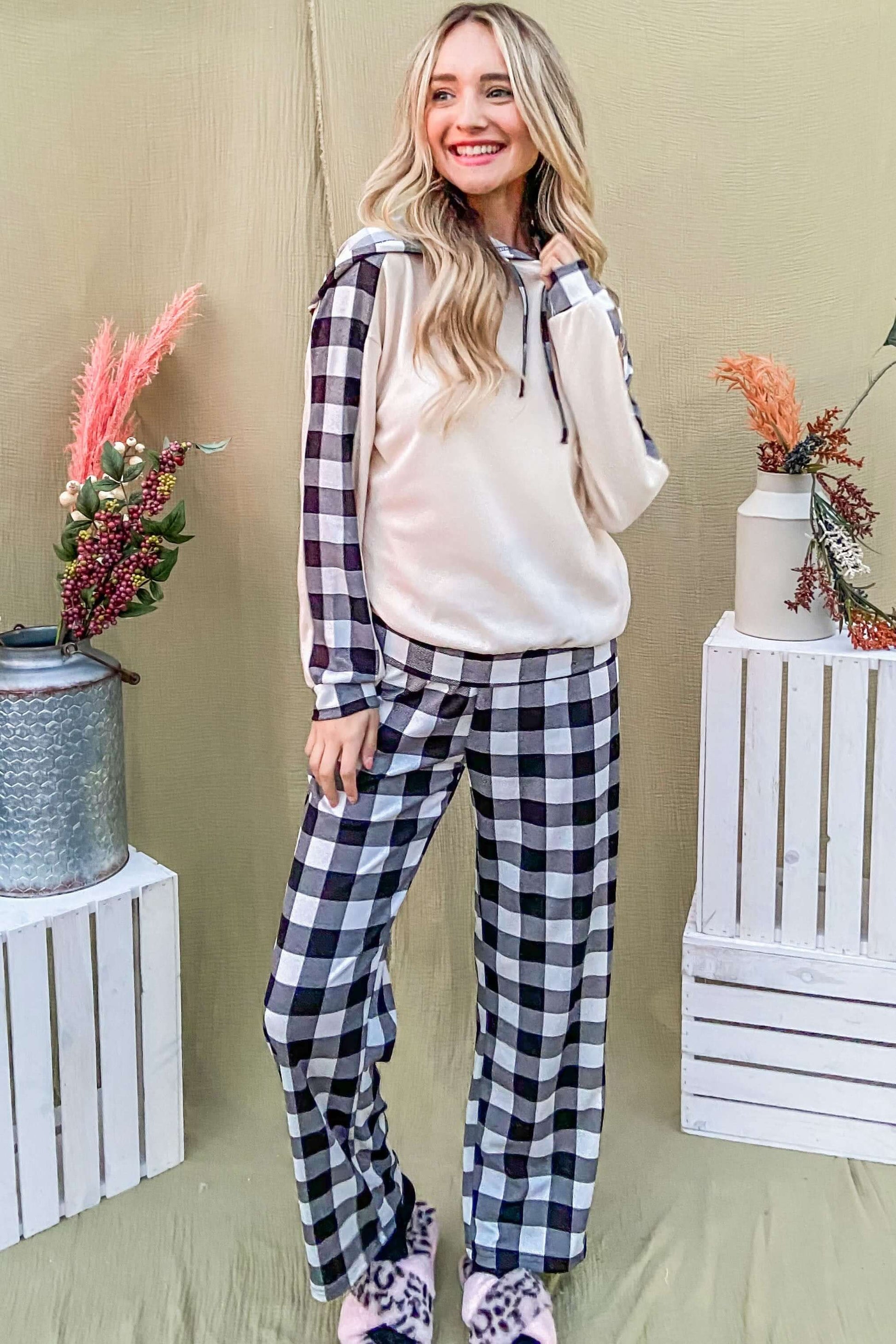 Stylish woman in drawstring hooded top and plaid pants lounge set, smiling against a colorful backdrop. Perfect for cozy lounging!