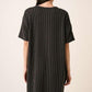 Back view of a woman wearing a Mittoshop Urban Rib Knit Short Sleeve Tee Dress with a trendy cap.