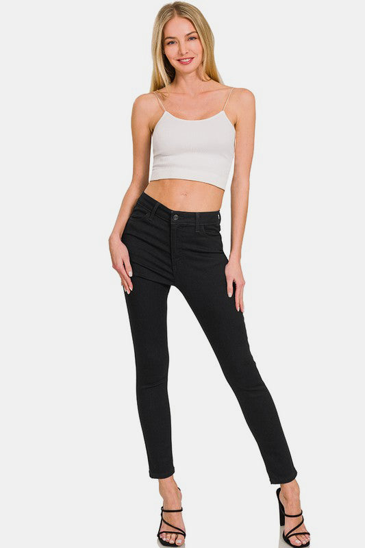 Model wearing Zenana high rise skinny jeans with pockets, styled with a simple crop top and heels for a chic look.