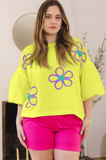 Woman wearing a Flower Embroidery Detail T-Shirt with colorful floral designs, paired with pink shorts, in a stylish and casual look