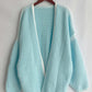 Tiffany Blue open front cardigan with dropped shoulders hanging on a wooden hanger, showcasing chic and relaxed style.