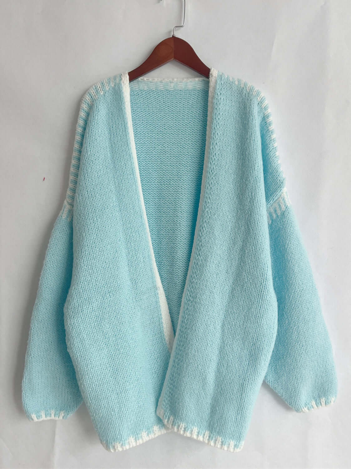 Tiffany Blue open front cardigan with dropped shoulders hanging on a wooden hanger, showcasing chic and relaxed style.