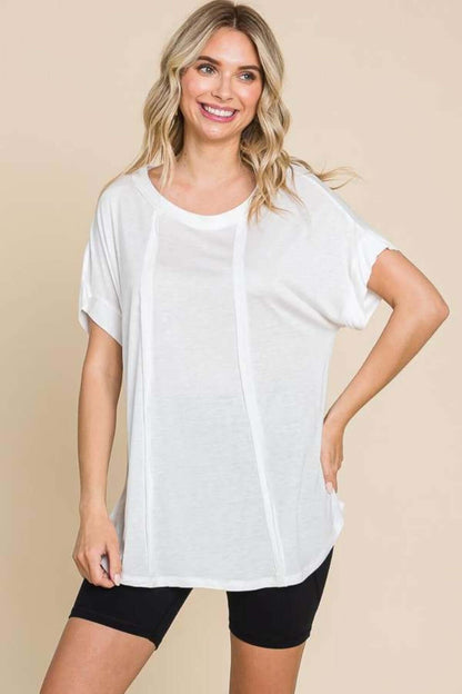 Woman wearing a white Round Neck Short Sleeve T-Shirt paired with black shorts, showcasing a comfortable and relaxed fit.