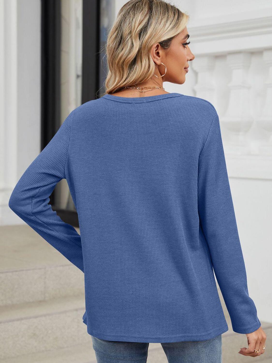 Woman wearing Bella Road Waffle-Knit Notched Long Sleeve T-Shirt in blue, viewed from the back.