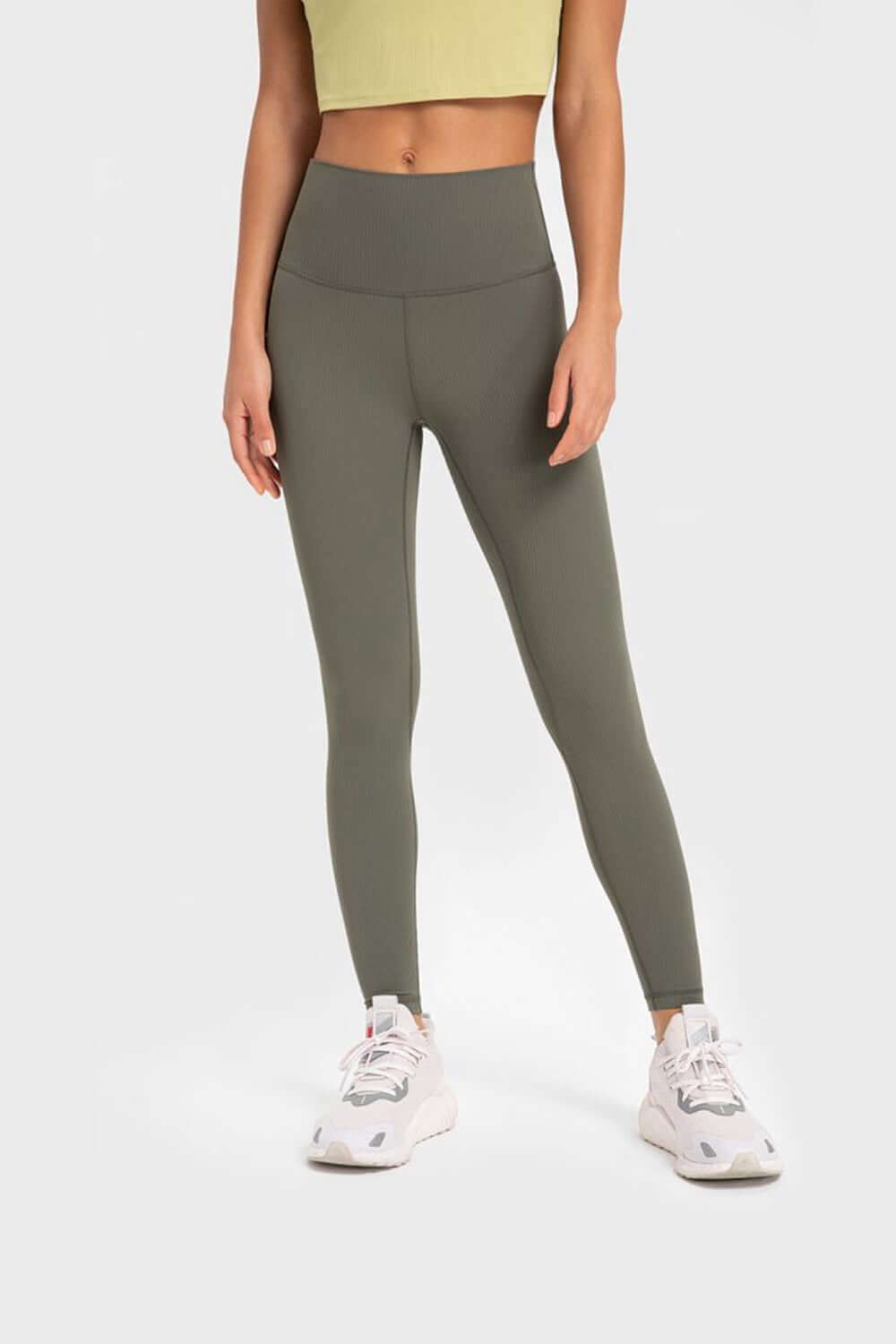 Model wearing Millennia Highly Stretchy Wide Waistband Yoga Leggings in olive green for a stylish workout look.