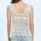 Elegant white lace sleeveless cover up, perfect for beach days, styled with denim shorts.