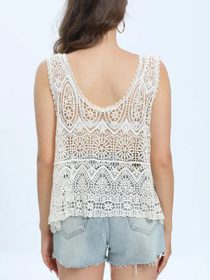 Elegant white lace sleeveless cover up, perfect for beach days, styled with denim shorts.