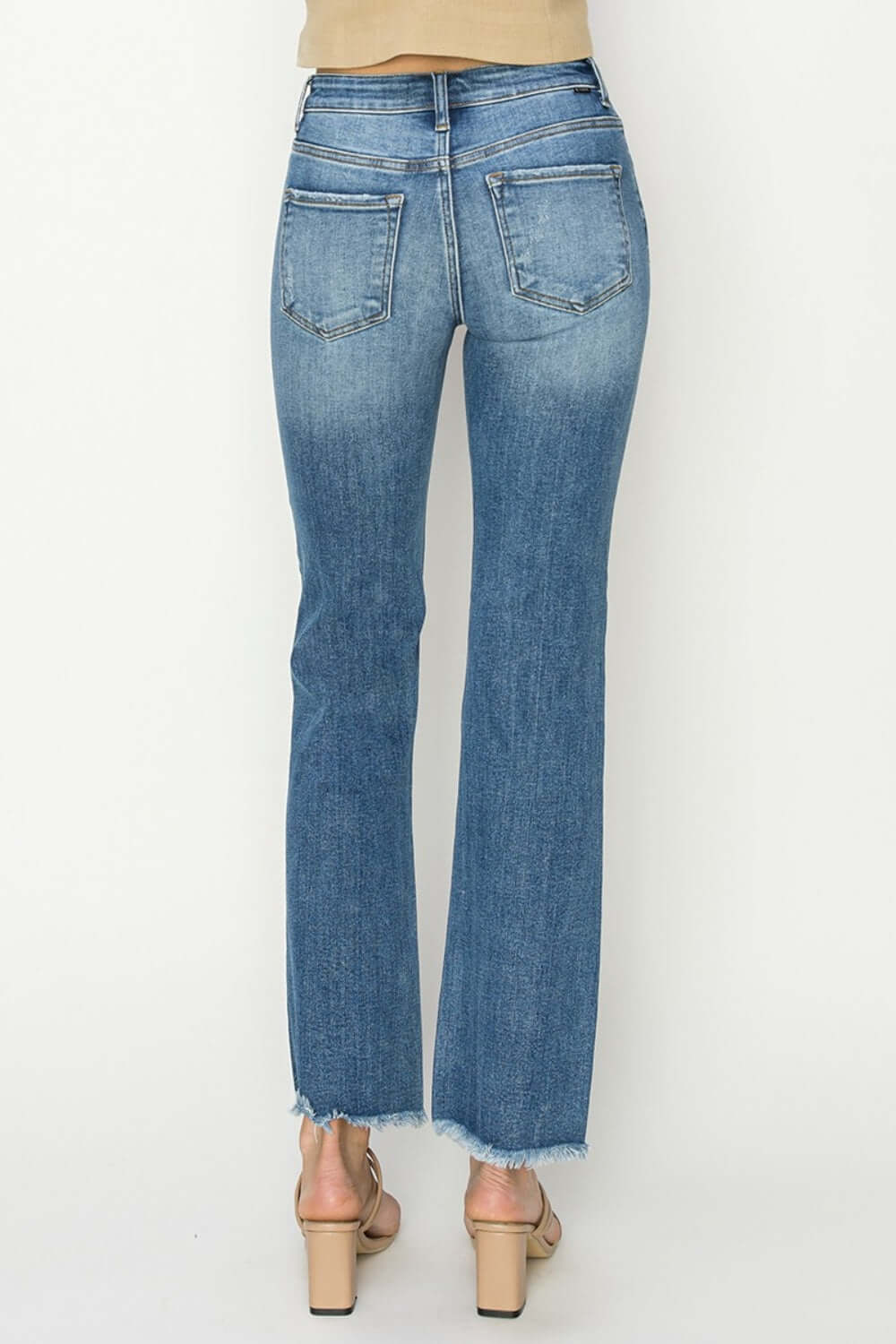 Back view of mid-rise frayed hem bootcut jeans by Risen Jeans, showcasing trendy denim style with frayed hem and cozy everyday fit.