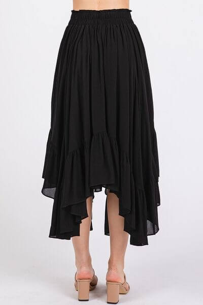 Back view of Mittoshop black handkerchief hem midi skirt with elastic waistband and flowy silhouette, perfect for any occasion.