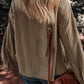 Woman wearing textured pocketed collared neck long sleeve shacket and carrying a brown leather crossbody bag