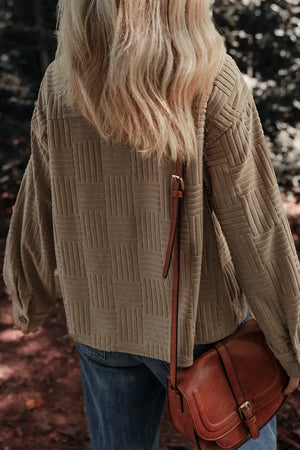 Woman wearing textured pocketed collared neck long sleeve shacket and carrying a brown leather crossbody bag