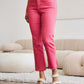 Woman wearing high waist tummy control raw hem jeans in pink by RFM Jeans