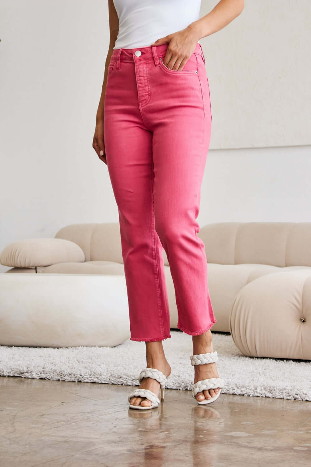 Woman wearing high waist tummy control raw hem jeans in pink by RFM Jeans