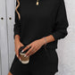 Woman wearing Double Take Round Neck Long Sleeve Top and Shorts Set in black, holds a coffee cup, showcasing casual and trendy style