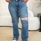 Mid Rise Destroyed Hem Distressed Judy Blue Jeans with ripped knee detail worn with black top and sneakers in a casual setting