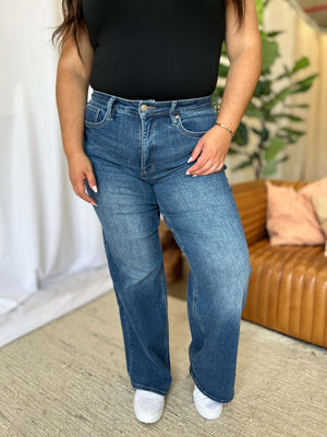 Woman wearing RFM Full Size High Rise Tummy Control Wide Leg Jeans in a stylish, comfortable, and relaxed fit.