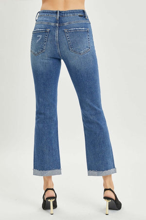 Back view of Button Fly Cropped Bootcut Jeans by Risen Jeans with frayed hems, styled with black heels.