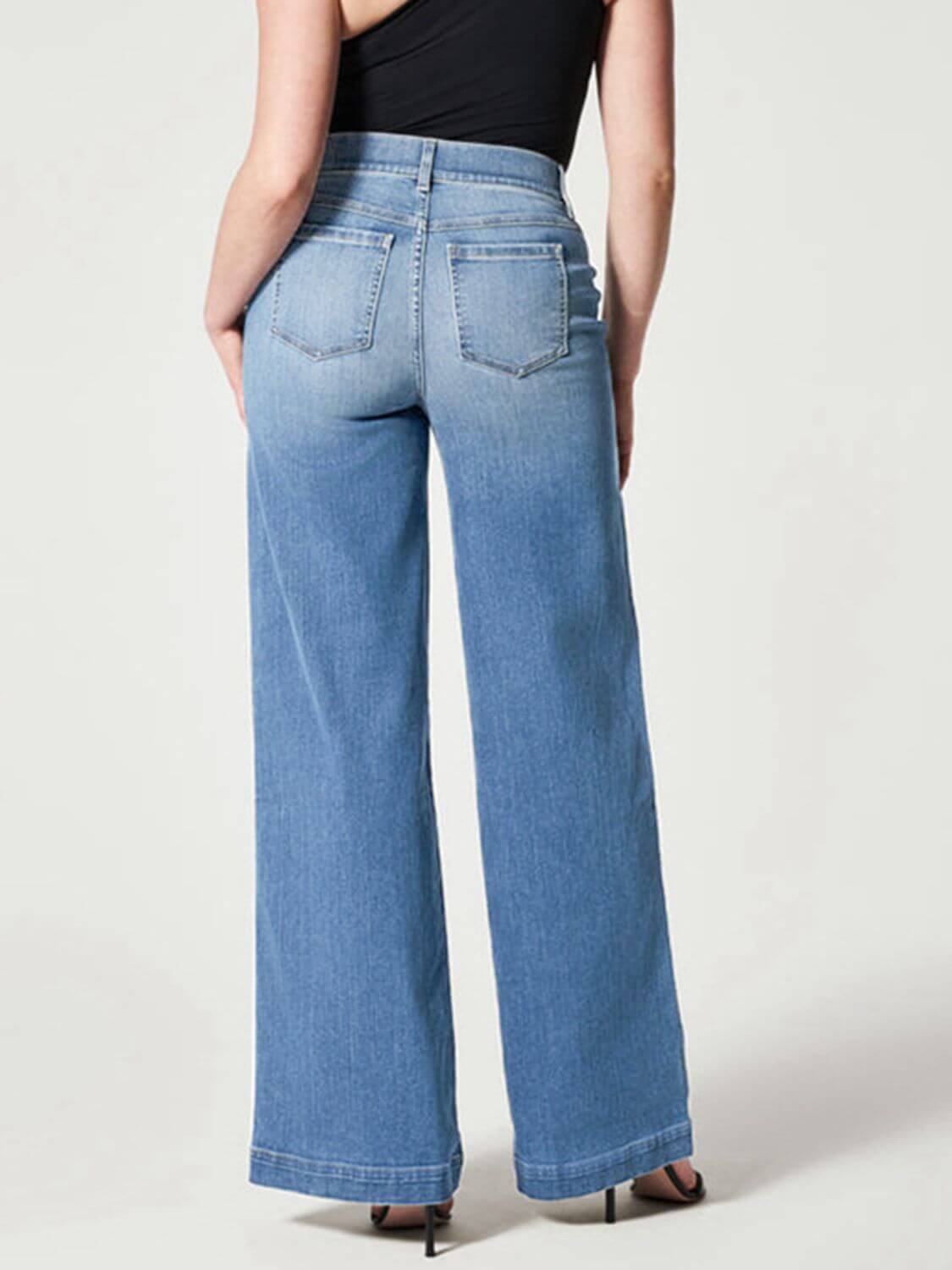 Woman wearing chic wide leg long jeans with moderate stretch, back view showing solid pattern and basic style, ideal for casual wear.