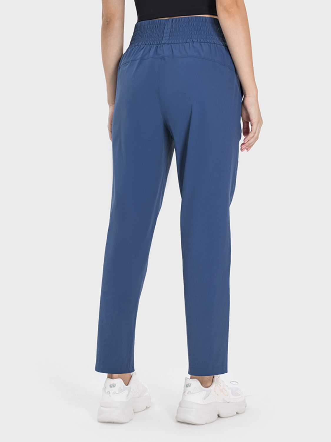 Rear view of Millennia Pocketed High Waist Active Pants in blue, featuring a comfortable waistband and sleek fit.