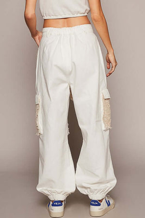 Back view of white crochet patch pants with elastic waistband and relaxed fit, perfect for trendy, casual outfits.