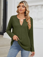 Woman wearing Bella Road waffle-knit notched long sleeve t-shirt in olive green, paired with jeans, standing outside a building.