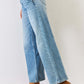 High Waist Wide Leg Jeans with slant pockets, zipper fly, and front pleats paired with brown ankle boots and a colorful top.