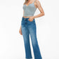 Stylish model wearing bytos Cat's Whiskers Mid Rise Ankle Jeans with a grey crop top and white sneakers.