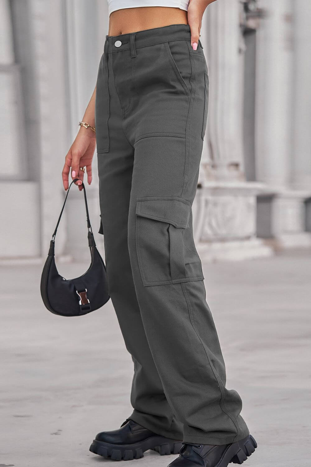 Woman wearing Baeful Long Straight Leg Jeans with Pockets holding a black handbag in a casual outdoor setting.