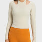 Millennia Halter Neck Long Sleeve Sporty Top in light beige, featuring stylish cutouts and paired with orange workout leggings.