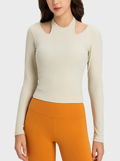 Millennia Halter Neck Long Sleeve Sporty Top in light beige, featuring stylish cutouts and paired with orange workout leggings.