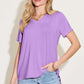 Woman wearing a Bamboo V-Neck High-Low T-Shirt in purple with slightly stretchy material, paired with blue jeans.