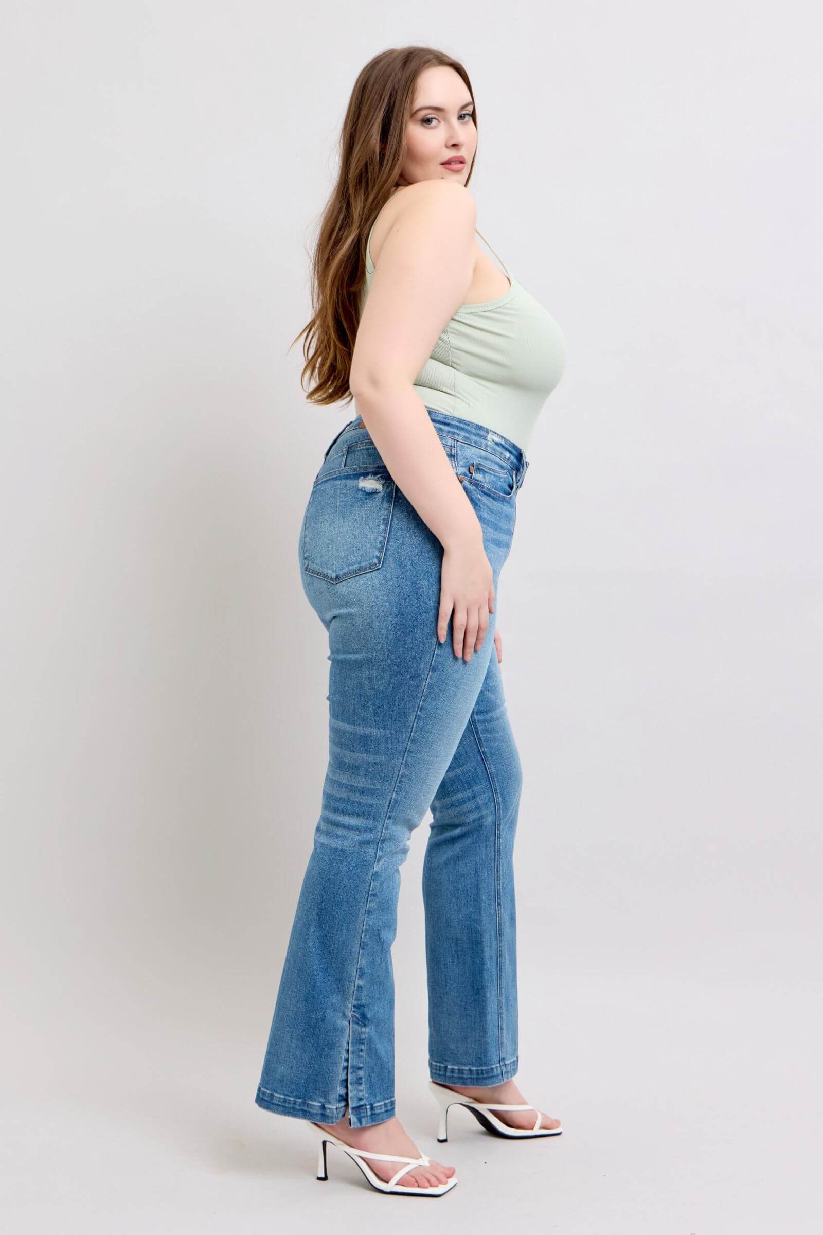 Model showcasing Judy Blue high waist tummy control vintage wash side slit slim boot jeans in a stylish pose.