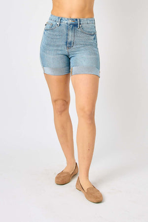 Woman wearing Judy Blue Jeans tummy control denim shorts in light wash with a rolled hem, perfect for a flattering summer look.