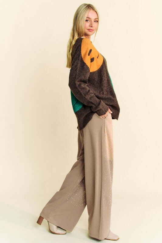 Model showcasing Davi & Dani Contrast Smile Oversize Sweater with playful smile design and relaxed fit, styled with wide-leg pants.