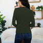 Woman wearing FAM-FAM Ruched Mock Neck Long Sleeve T-Shirt in Army Green, standing in stylish living room, showing back view.