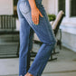 Woman wearing Bella Road Santa Graphic Distressed Jeans with Pockets showing side view with slight stretch fabric, standing on patio.