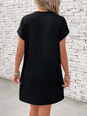 Back view of Letter Graphic Short Sleeve Mini Tee Dress in black, showing slightly stretchy fabric and basic style, worn by a model.