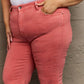 Woman wearing Bailey High Waist Side Slit Flare Jeans in coral pink, crafted from stretchy denim and designed to accentuate curves.