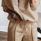 Woman wearing Bella Road Zip Up Long Sleeve Top and Pants Set in beige, featuring a trendy drawstring and comfortable fit.