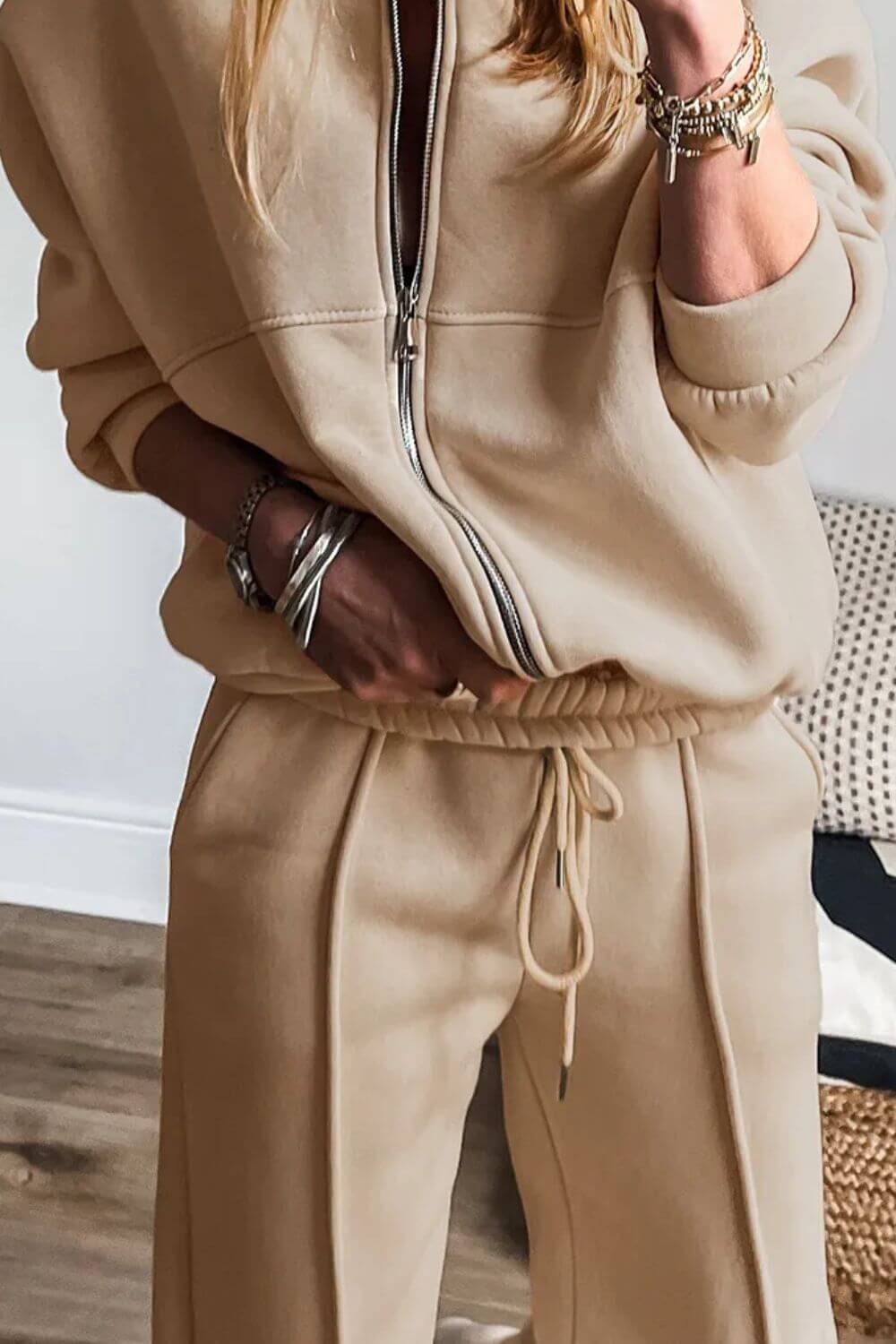 Woman wearing Bella Road Zip Up Long Sleeve Top and Pants Set in beige, featuring a trendy drawstring and comfortable fit.