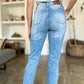 Woman wearing Judy Blue distressed straight jeans with patch pockets.