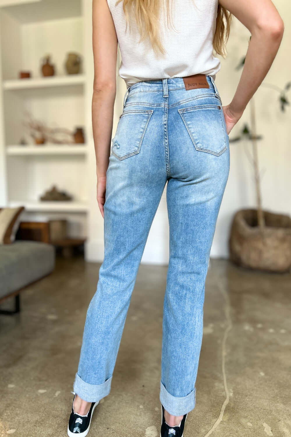 Woman wearing Judy Blue distressed straight jeans with patch pockets.