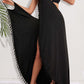 Woman wearing a black backless tassel surplice spaghetti strap cover-up dress over a bikini.