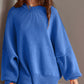 Woman wearing blue Double Take Side Slit Round Neck Long Sleeve Sweater with moderate stretch and classic round neck.