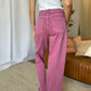 Woman wearing RFM Full Size High Rise Garment Dye Wide Leg Jeans in pink color, showcasing the stylish wide-leg silhouette.