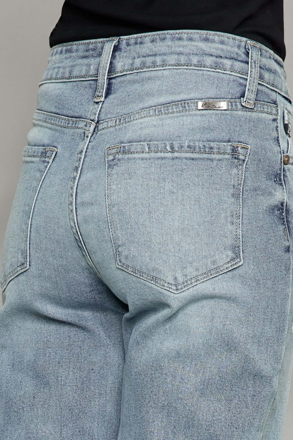 Close-up of High Waist Raw Hem Cropped Wide Leg Jeans showing back pocket detail and raw hem finish.