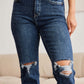 Woman wearing RFM Jeans Crop Dylan Full Size Tummy Control Distressed High Waist Raw Hem Jeans showcasing trendy distressed details.